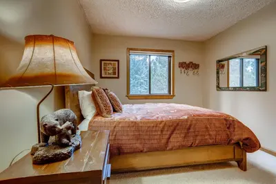 a bedroom with a bed and a lamp on a table at Casa de Montagne Home: High-End Log Home, Downtown Frisco in Frisco