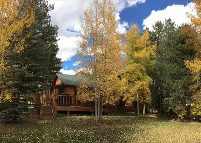 a large log cabin in the middle of trees at Casa de Montagne Home: High-End Log Home, Downtown Frisco in Frisco