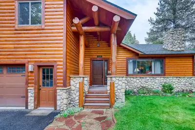 a log house with a door and a stone wall at Casa de Montagne Home: High-End Log Home, Downtown Frisco in Frisco