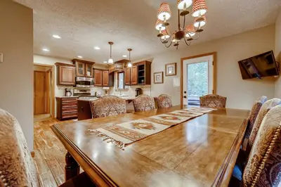 a kitchen and dining room with a wooden table and chairs at Casa de Montagne Home: High-End Log Home, Downtown Frisco in Frisco