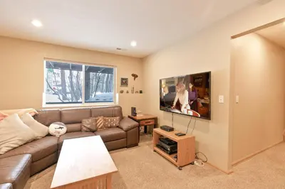 a living room with a brown couch and a window at Solitude Station Home: Walk to Downtown in Frisco