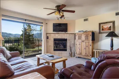 a living room with a couch and a fireplace at Lake Forest Shoreview Condo: Fantastic Views in Frisco
