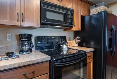 a kitchen with a black stove and a microwave at Lake Forest Shoreview Condo: Fantastic Views in Frisco