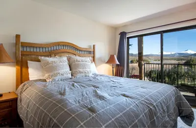 a bedroom with a bed and a large window at Lake Forest Shoreview Condo: Fantastic Views in Frisco