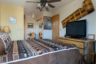 a bedroom with a bed and a flat screen tv at Lake Forest Summit Condo: Great Penthouse Views in Frisco