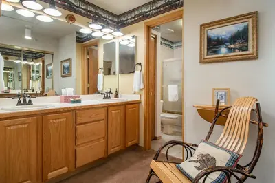 a bathroom with a sink and a toilet and a chair at Lake Forest Summit Condo: Great Penthouse Views in Frisco
