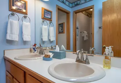 a bathroom with two sinks and a mirror at Lake Forest Summit Condo: Great Penthouse Views in Frisco