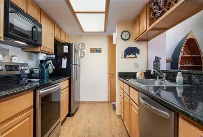 a large kitchen with a sink and a refrigerator at Lake Forest Summit Condo: Great Penthouse Views in Frisco