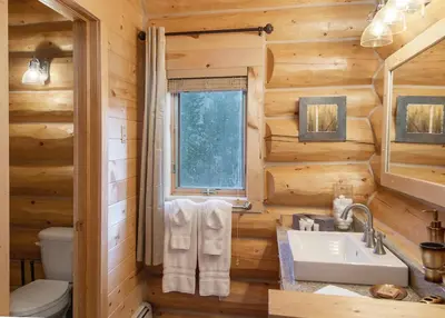 a log cabin bathroom with a sink and a window at Elk Meadow Lodge: Luxury Log Home, Hot Tub in Breckenridge