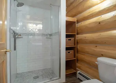 a bathroom with a shower with a toilet and wooden walls at Elk Meadow Lodge: Luxury Log Home, Hot Tub in Breckenridge