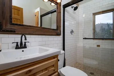 a bathroom with a sink and a toilet and a mirror at Elk Meadow Lodge: Luxury Log Home, Hot Tub in Breckenridge