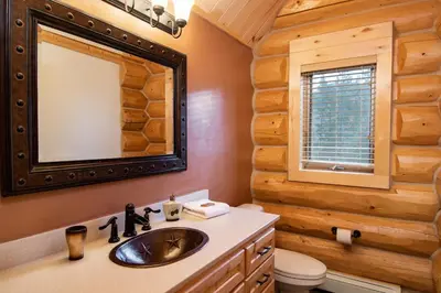 a bathroom with a sink and a mirror in a log cabin at Elk Meadow Lodge: Luxury Log Home, Hot Tub in Breckenridge