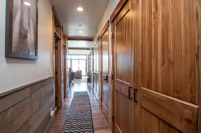 a hallway with wooden doors and a tile floor at Frisco Sports Chalet Tenmile Condo: Stylish, On Shuttle Route in Frisco