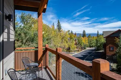 a balcony with a chair and a view of trees at Frisco Sports Chalet Tenmile Condo: Stylish, On Shuttle Route in Frisco