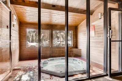 a hot tub in a room with glass doors at Cedar Lodge Peak One Studio Condo: Downtown Frisco in Frisco