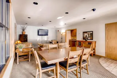 a dining room with a wooden table and chairs at Cedar Lodge Peak One Studio Condo: Downtown Frisco in Frisco