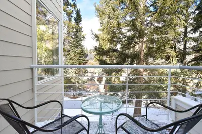 a patio with two chairs and a table on a balcony at River Glen Brookside Condo: Fantastic Frisco Location in Frisco