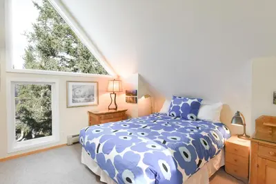 a bedroom with a blue and white bed and a window at River Glen Brookside Condo: Fantastic Frisco Location in Frisco