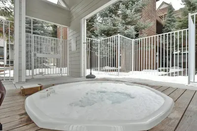 a jacuzzi tub on the deck of a house at River Glen Brookside Condo: Fantastic Frisco Location in Frisco
