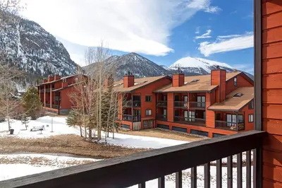 a large building with snow covered mountains in the background at Mountainside Peakview Condo: Cool Location, Updates in Frisco