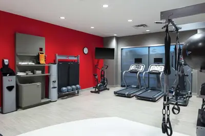 a gym with two treadmills and a red wall at Hilton Garden Inn Denver/Thornton in Thornton