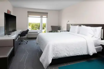 a hotel room with a bed and a desk and a television at Hilton Garden Inn Denver/Thornton in Thornton