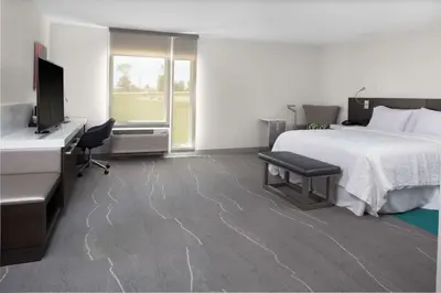 a bedroom with a bed and a desk and a television at Hilton Garden Inn Denver/Thornton in Thornton