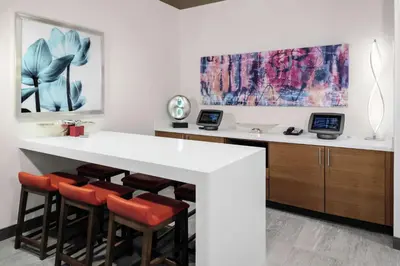 a kitchen with a white counter and stools at Hilton Garden Inn Denver/Thornton in Thornton