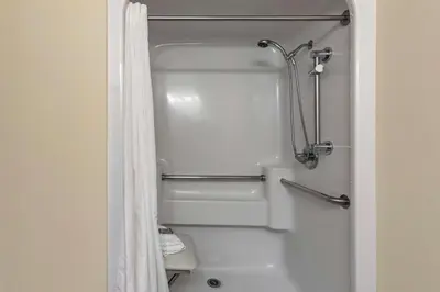 a shower in a bathroom with a white shower curtain at Best Western Brighton Inn in Brighton