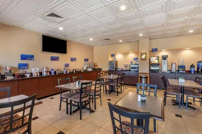 a restaurant with tables and chairs and a bar at Best Western Brighton Inn in Brighton