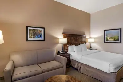 a hotel room with a bed and a couch at Best Western Brighton Inn in Brighton