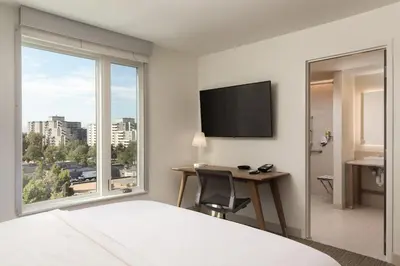 a hotel room with a bed and a desk and a window at Element Denver Downtown East in Denver