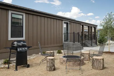 a patio with chairs and a grill and a house at Sun Outdoors Rocky Mountains in Granby