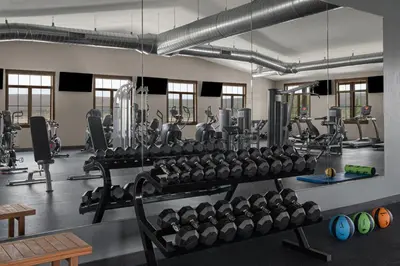 a gym with several rows of dumbbells and weights at Sun Outdoors Rocky Mountains in Granby
