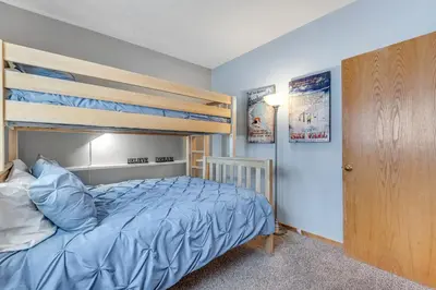 a bedroom with a bunk bed with blue sheets at Timber Ridge Retreat in Silverthorne