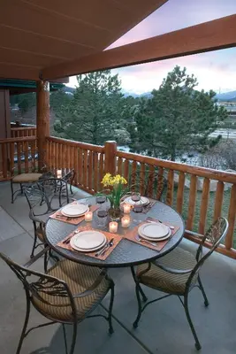 a table and chairs on a porch with a view at WorldMark Estes Park in Estes Park