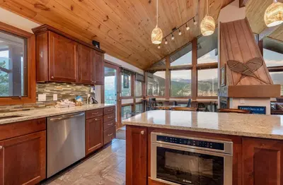 a large kitchen with wooden cabinets and a large island at Herondale Luxury Home Home in Estes Park