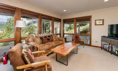 a living room with couches and a table and a tv at Herondale Luxury Home Home in Estes Park