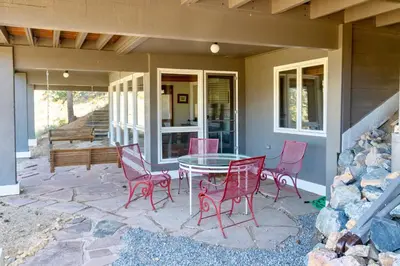 a patio with red chairs and a table on a house at Herondale Luxury Home Home in Estes Park
