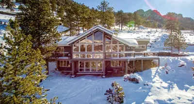 a large house in the snow with snow at Herondale Luxury Home Home in Estes Park
