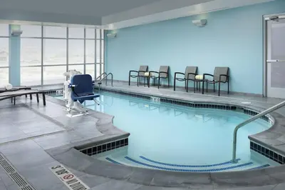 a large swimming pool with chairs in a building at SpringHill Suites by Marriott Loveland Fort Collins/Windsor in Windsor