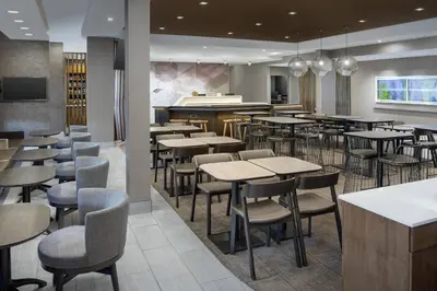 a restaurant with tables and chairs and a bar at SpringHill Suites by Marriott Loveland Fort Collins/Windsor in Windsor