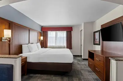 a hotel room with a bed and a flat screen tv at Comfort Suites Denver Tech Center in Centennial