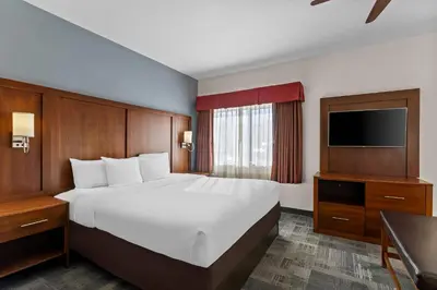 a hotel room with a large bed and a flat screen tv at Comfort Suites Denver Tech Center in Centennial