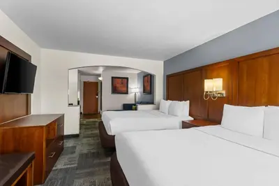 a hotel room with two beds and a flat screen tv at Comfort Suites Denver Tech Center in Centennial