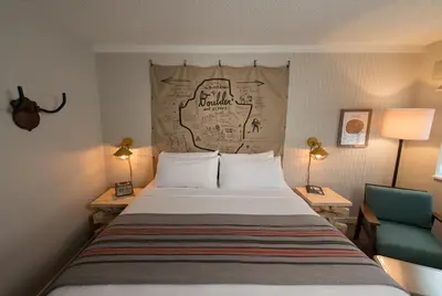 a bedroom with a bed with a map on the headboard at Basecamp Boulder in Boulder