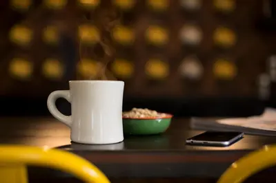 a white coffee cup on a table with a bowl of food at Basecamp Boulder in Boulder