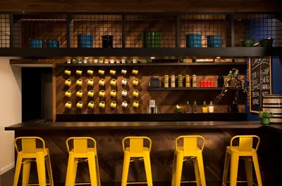 a bar with three yellow stools in a restaurant at Basecamp Boulder in Boulder