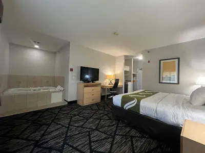 a hotel room with a bed and a tub and a television at Quality Inn & Suites Loveland in Loveland