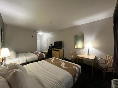 a hotel room with two beds and a desk at Quality Inn & Suites Loveland in Loveland